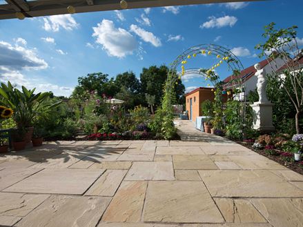 Natuurlijke tuin met lichtgekleurde Yellow Mint zandsteen en een helderblauwe lucht