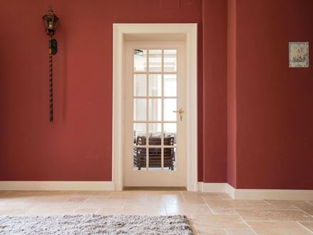 Entree met travertin tegels en rode muren