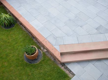 Kalkstenen terras met gras en planten