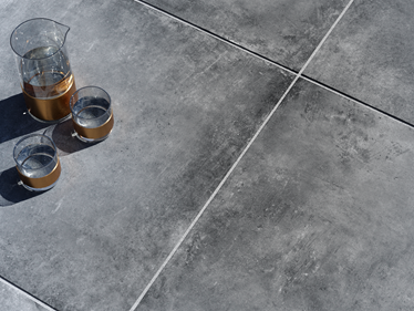 Donker betonlook Vulkano terrasplaat met karaf en glazen