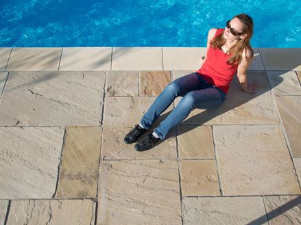Avondzon op de Yellow Mint zandsteenplaten met een vrouw bij het zwembad