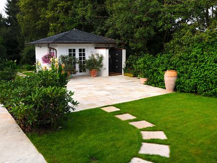 Tuinhuisje met gazon aan de voorkant en Yellow Mint zandstenen platen