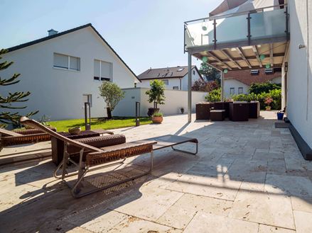 Zonnig terras met twee ligstoelen en medium travertin vloeren