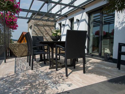 Terras met zwart meubilair en Natura travertin in houtlook
