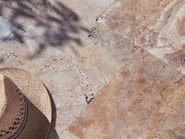 Travertin Scabas terras in zonlicht met strohoed