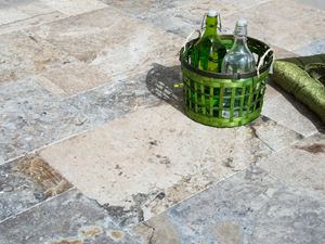 Groene flessenmand op travertin zilveren terrasplaten