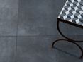 Betonlook tegels: trendy stedelijke stijl Donkere betonlook tegels met bijzettafel van bovenaf gefotografeerd