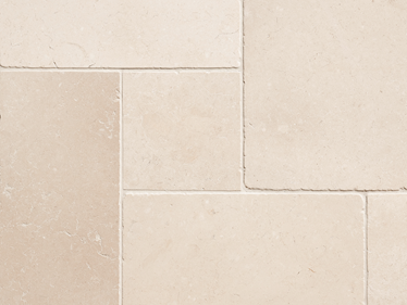 Close-up van beige kalkstenen tegels met smalle voeg