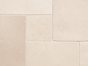 Close-up van beige kalkstenen tegels met smalle voeg