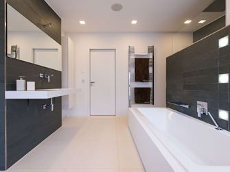 Moderne badkamer met lichtgekleurde kalksteentegels op de vloer en donker leisteen op de muur