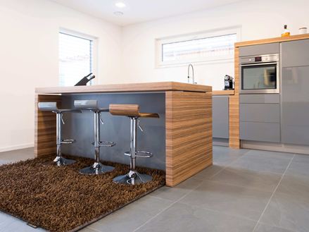 Keuken met open bar, moderne houten elementen en donkere leisteenvloer