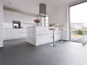 Witte keuken met metalen elementen op grijze leistenen tegel met gedeeld oppervlak