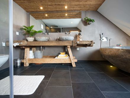 Rustieke badkamer met leistenen tegels en houten meubels