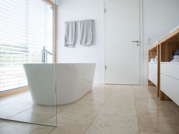 Moderne badkamer met Classic Light travertin en vrijstaand bad