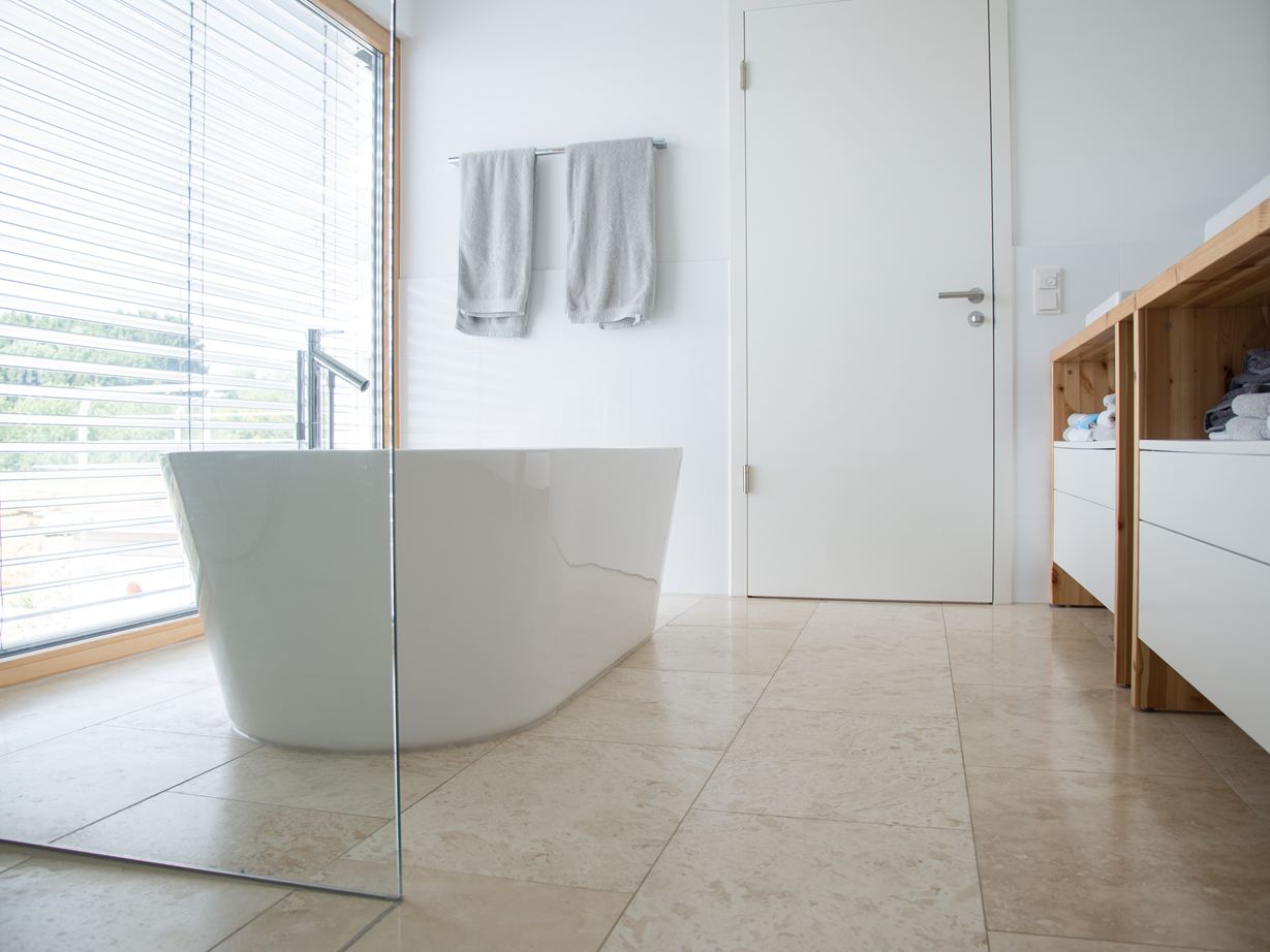 Moderne badkamer met Classic Light travertin en vrijstaand bad
