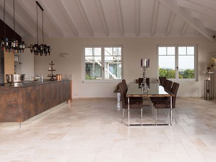 Lichte travertin tegels in een gemengd patroon in een moderne keuken met eettafel en kookeiland