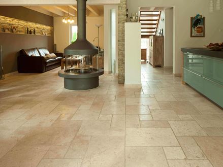 Woon- en eetkamer met zithoek en aanrecht op getrommelde lichte travertin tegels