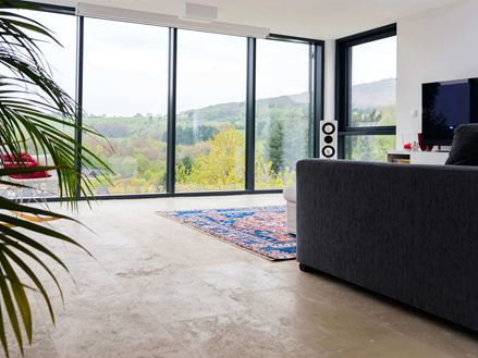 Woonkamer met Medium Line travertin tegels en groot raam aan de voorkant