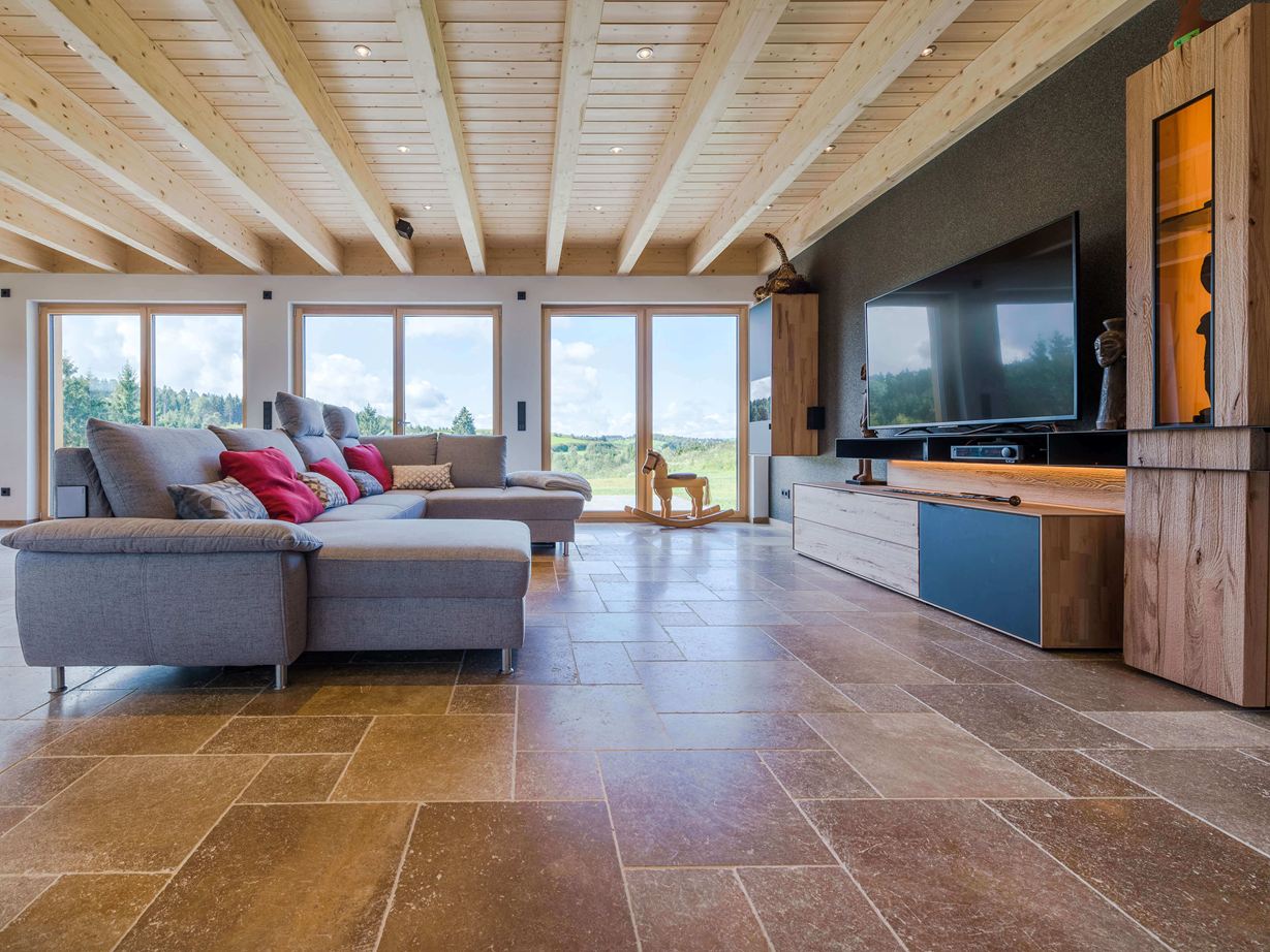 Woonkamer met grijze bank en walnoot-bruine Noce SELECT travertin tegels