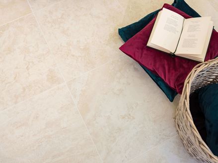 Tegels in travertin-look met kussens en een open boek