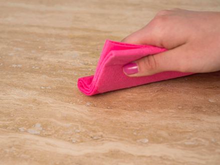 Handdoekje met roze doekje over beige natuursteen