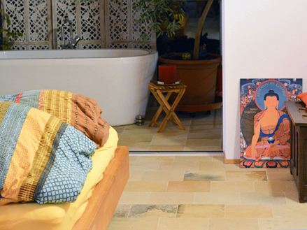 Slaapkamer met kleurrijke kussens en kalkstenen vloer van Solnhofen