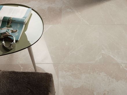 Ronde tafel met boek en klok op Burdur Cream marmeren tegel