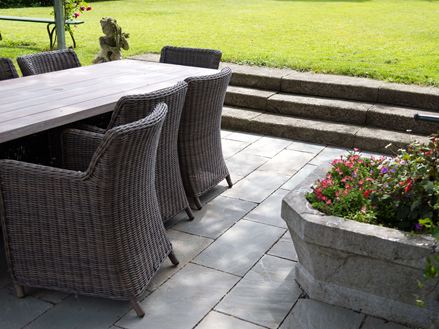 Rotanmeubels op grijze zandstenen platen