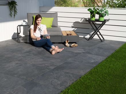 Vrouw zittend op terrasplaten Alpine Black