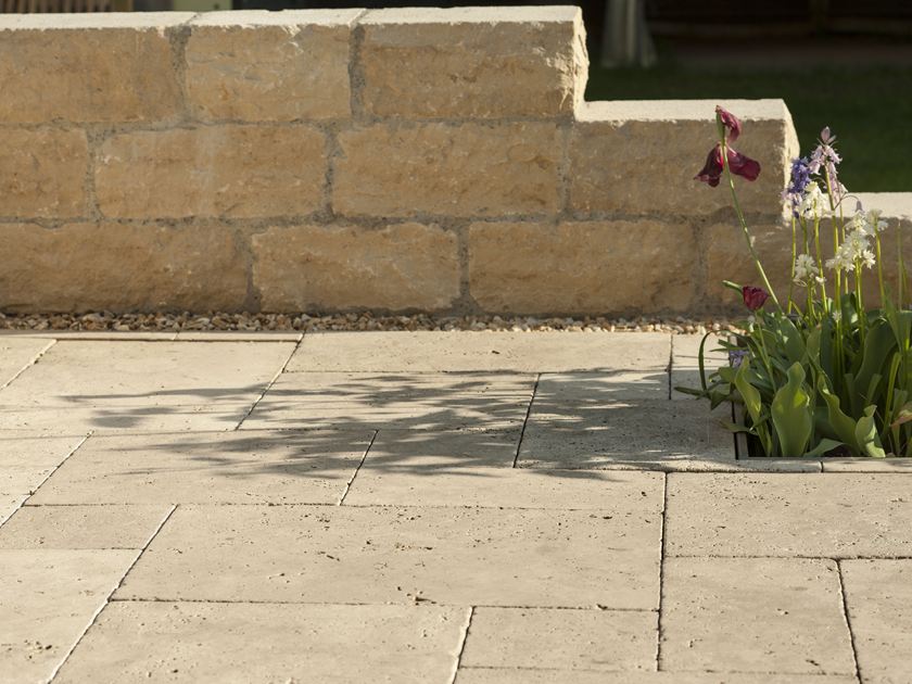 Medium Select travertin plaat met natuurstenen muur en bloemen op de achtergrond