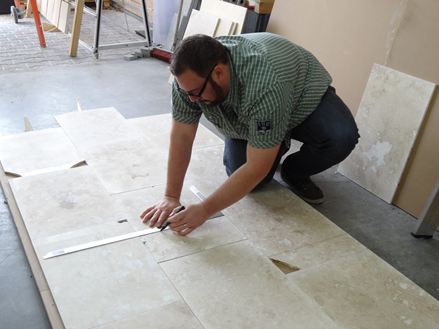 Adalbert Lange markeert de onvolkomenheden in de tegels, zodat ze vervolgens in platen kunnen worden gesneden.