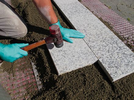 Platen worden gelegd in een korrelpatroon op steenslag draaglaag