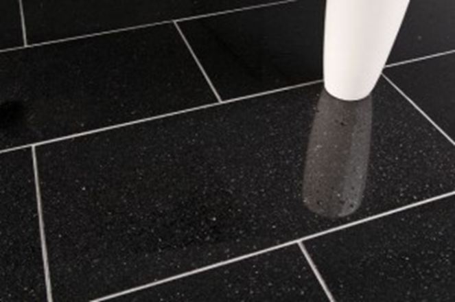 Een witte vaas op zwarte granieten tegels met lichtgekleurde voegen