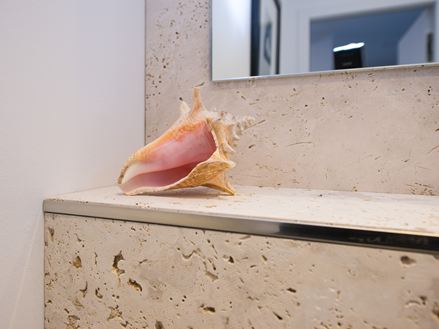 Travertin wandtegels met schelpdecoratie in de badkamer