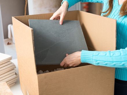 Werknemer verpakt een natuursteenmonster in een doos