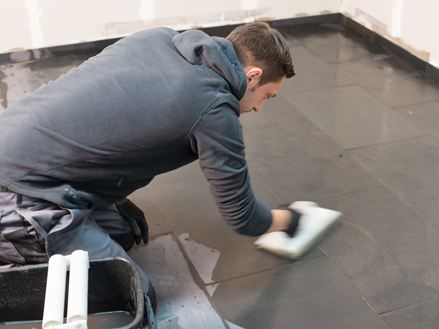 Tegelzetter reinigt de vloer