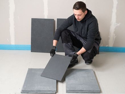 Tegelzetter sorteert leistenen tegels voor het leggen