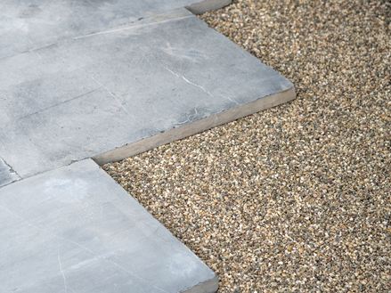 Blauwgrijze kalksteenplaten in een bed van hoogwaardige steenslag